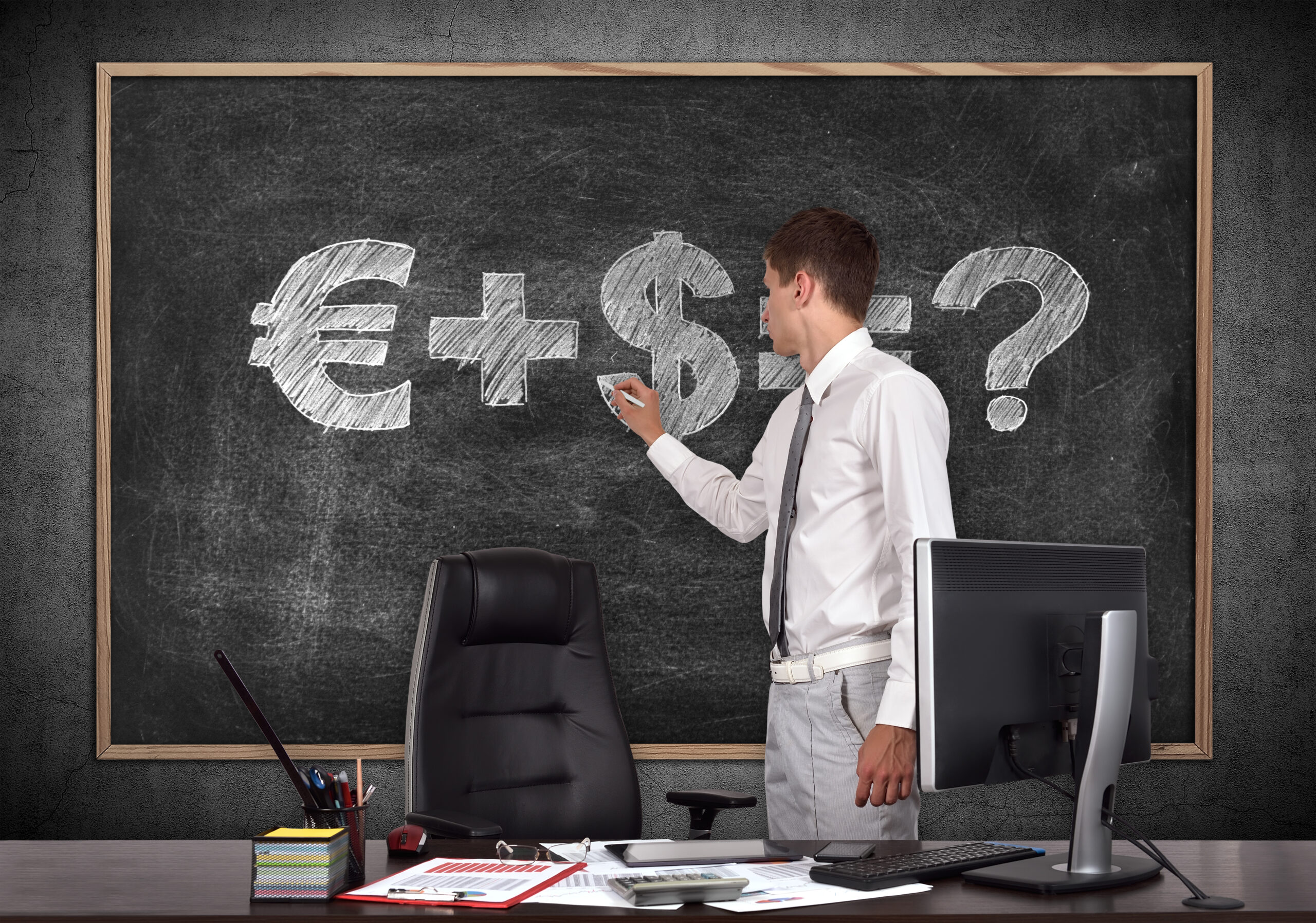 businessman in office drawing money formula on blackboard